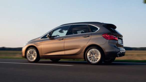 BMW 225xe Active Tourer híbrido plug-in, F45, perspetiva lateral a três quartos, em movimento BMW 225xe Active Tourer híbrido plug-in, F45, perspetiva lateral a três quartos, em movimento na rua
