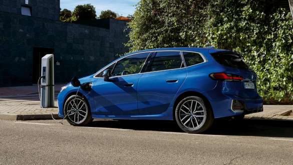 BMW Série 2 Active Tourer 230e híbrido plug-in, U06, 2021, parado num posto de carregamento BMW Série 2 Active Tourer 230e híbrido plug-in, U06, 2021, pintura azul Portimao M metalizada, perspetiva lateral, parado num posto de carregamento