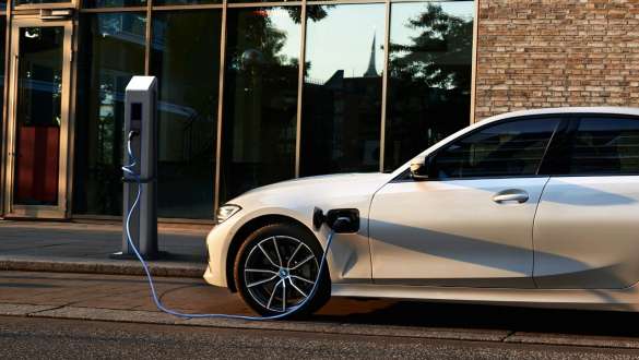 BMW Série 3 Berlina híbrido plug-in, 2021, G20, perspetiva lateral BMW Série 3 Berlina híbrido plug-in, 2021, G20, perspetiva lateral, a carregar num posto de carregamento