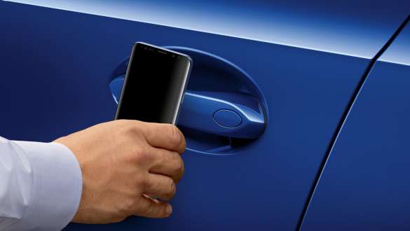 BMW Série 3 Berlina, chave digital BMW. Grande plano da porta do condutor do BMW Série 3 Berlina com um telemóvel Samsung à frente do puxador da porta.