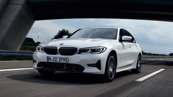 BMW Série 3 Berlina híbrido plug-in, 2021, G20, perspetiva frontal a três quartos, em movimento BMW Série 3 Berlina híbrido plug-in, 2021, G20, perspetiva frontal a três quartos em movimento na rua