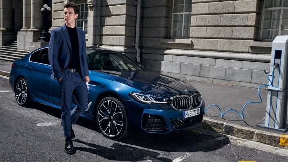BMW Série 5 Berlina híbrido plug-in, 2021, G30, perspetiva frontal a três quartos, a carregar BMW Série 5 Berlina híbrido plug-in, 2021, G30, perspetiva frontal a três quartos, a carregar com um modelo