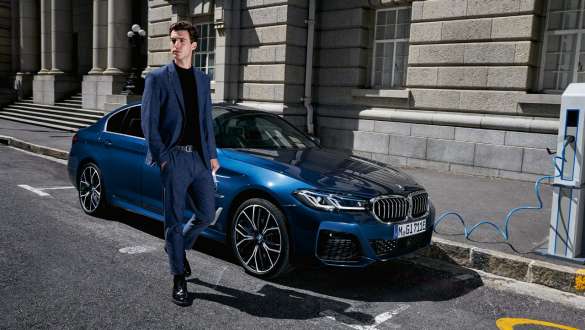 BMW Série 5 Berlina híbrido plug-in, 2021, G30, perspetiva frontal a três quartos, a carregar BMW Série 5 Berlina híbrido plug-in, 2021, G30, perspetiva frontal a três quartos, a carregar com um modelo