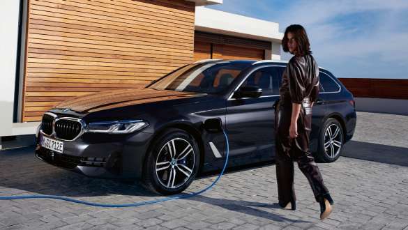 BMW Série 5 Touring híbrido plug-in, 2021, G31, perspetiva lateral a três quartos, a carregar BMW Série 5 Touring híbrido plug-in, 2021, G31, perspetiva lateral a três quartos, a carregar com um modelo