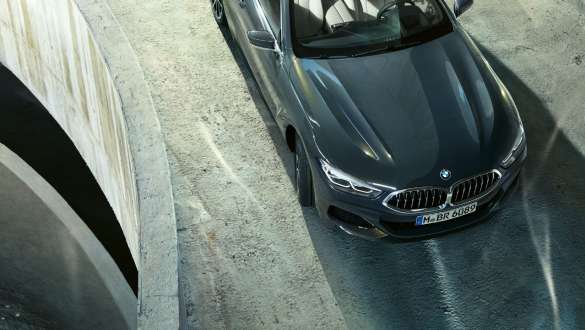 BMW M850i xDrive em cinza Dravit metalizado, em movimento, dianteira, perspetiva de topo, direção ativa integral. BMW M850i xDrive em cinza Dravit metalizado, em movimento, dianteira, perspetiva de topo, direção ativa integral.