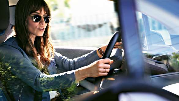 Mulher com óculos de sol a conduzir um BMW i3 I01 Mulher com óculos de sol a conduzir um BMW i3 I01