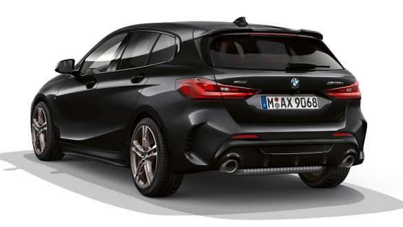 Pack aerodinâmico M. BMW M135i xDrive na pintura preto Sapphire metalizada, com pack aerodinâmico M, perspetiva traseira.