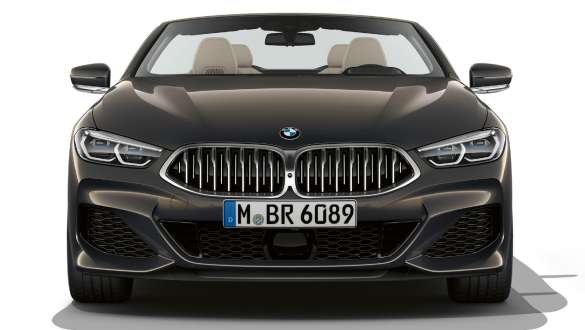 BMW M850i xDrive Cabrio, dianteira. BMW M850i xDrive Cabrio na pintura cinza Dravit metalizada com capota flexível aberta, dianteira com grelha dupla em forma de rim em cinza Cerium Galvanic.
