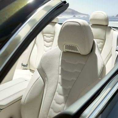 BMW M850i xDrive Cabrio, bancos multifuncionais para condutor e passageiro da frente. BMW M850i xDrive Cabrio em cinza Dravit metalizada com capota flexível aberta, interior com bancos multifuncionais em pele Merino BMW Individual em branco Ivory.