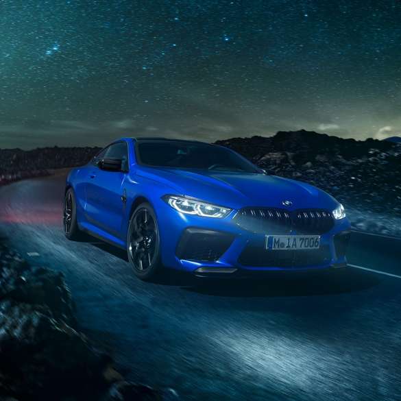 BMW M8 Competition Coupé, perspetiva lateral. BMW M8 Competition Coupé na pintura azul Marina Bay metalizada, parado frente ao deserto, num cenário de lua cheia, perspetiva lateral.