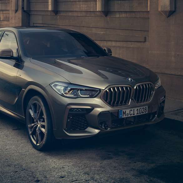 BMW X6 M50i com motor M TwinPower Turbo de 8 cilindros a gasolina BMW X6 M50i com motor M TwinPower Turbo de 8 cilindros a gasolina, G06, pintura Manhattan metalizada, perspetiva lateral a três quartos