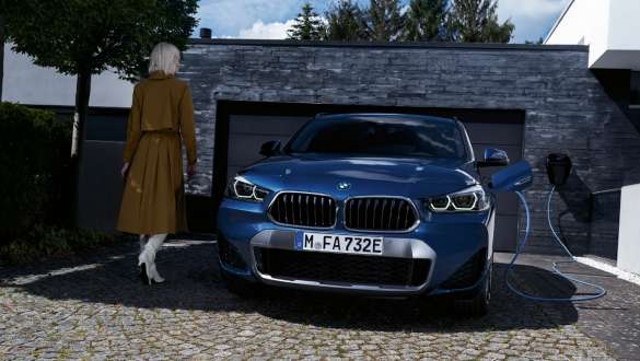 BMW X2 xDrive25e híbrido plug-in, F39, perspetiva frontal, em frente a uma garagem BMW X2 xDrive25e híbrido plug-in, F39, perspetiva frontal, em frente a uma garagem