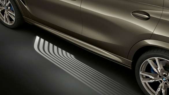 Tapete de luzes de entrada BMW. Perspetiva de perfil do BMW X6 com destaque para o tapete de luzes de entrada.