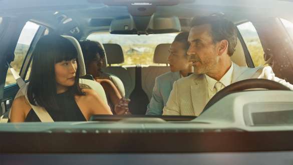 Controlo por gestos BMW Homem e mulher sentados no veículo, a mulher utiliza o sistema de controlo por gestos BMW