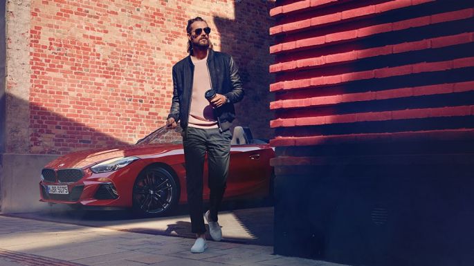 O BMW Z4 Roadster numa rua secundária Um homem numa rua secundária à frente do BMW Z4 Roadster