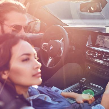O BMW Z4 Roadster com um homem e uma mulher Um homem e uma mulher morenos no BMW Z4 Roadster