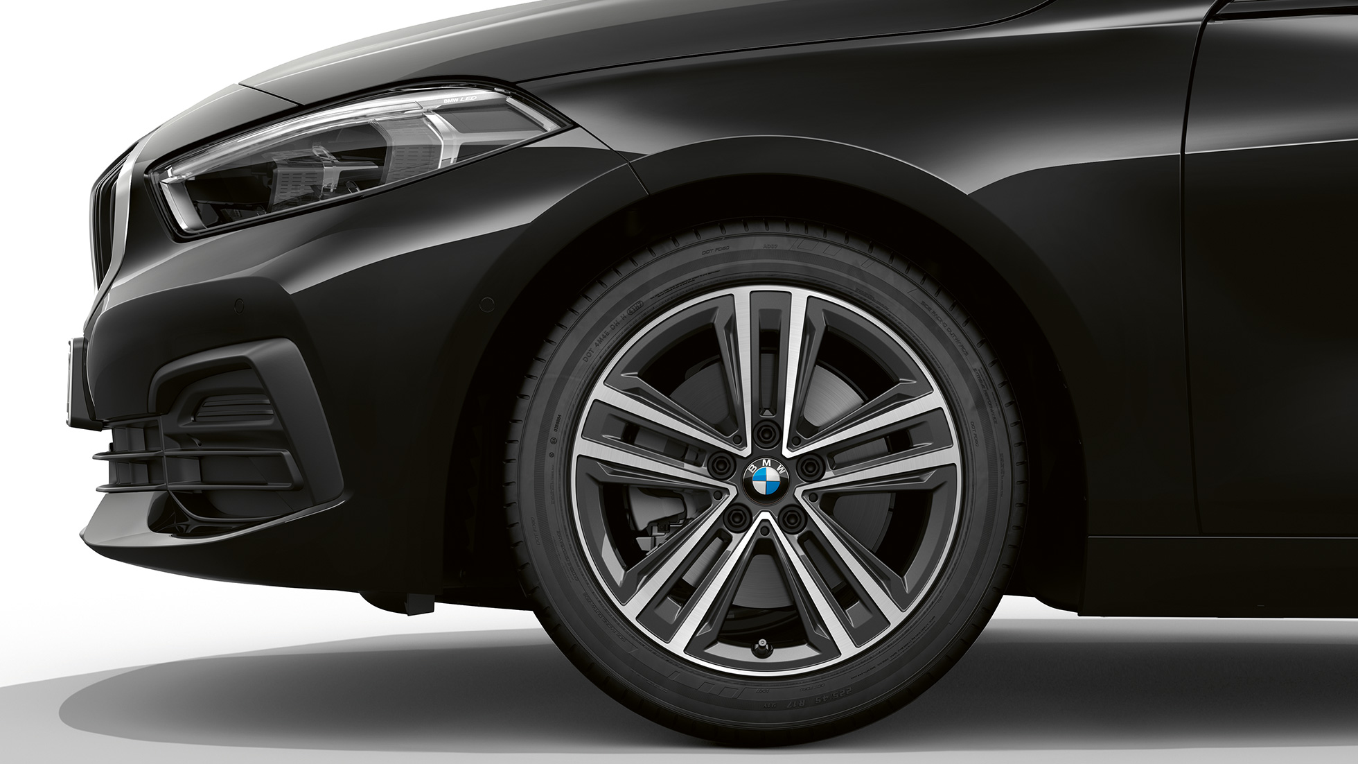 Jantes de liga leve BMW 517 de raios em estrela de 16". BMW Série 1 na pintura preto, Versão Advantage, perspetiva lateral da dianteira com jantes de liga leve BMW 517 de raios em estrela de 16''.