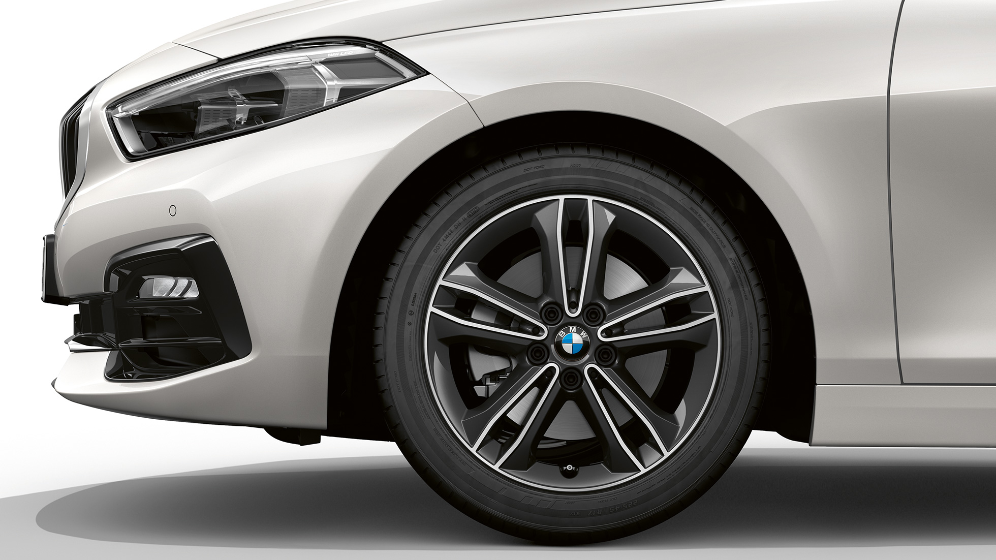 Jantes de liga leve BMW 549 de raios duplos de 17". BMW Série 1 na pintura branco Mineral metalizada, Versão Line Sport, perspetiva lateral da dianteira com jantes de liga leve BMW 549 de raios duplos de 17''.