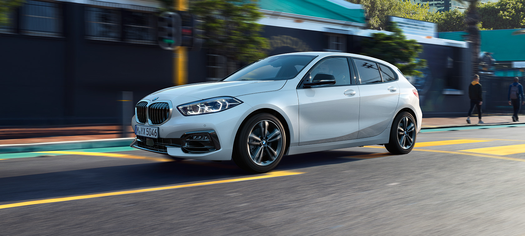 BMW Série 1 Versão Line Sport, perspetiva lateral a três quartos. BMW Série 1 na pintura branco Mineral metalizada, Versão Line Sport, perspetiva lateral a três quartos da condução do automóvel.