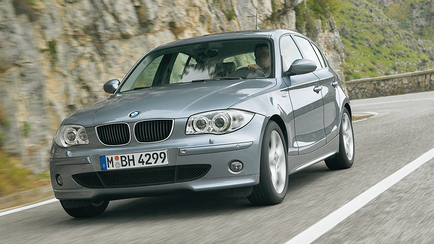BMW Série 1 (E87), perspetiva dianteira a três quartos, em movimento em frente a uma encosta BMW Série 1 (E87), perspetiva dianteira a três quartos, em movimento em frente a uma encosta