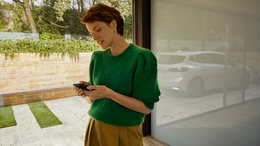 BMW Service Inclusive, mulher com smartphone na mão Mulher com smartphone na mão, BMW Service Inclusive