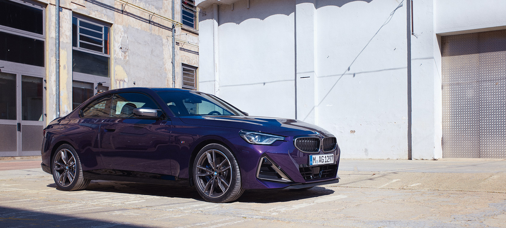 Perspetiva lateral a três quartos do BMW Série 2 Coupé, G42, 2021 BMW Série 2 Coupé, G42, 2021, pintura Thundernight metalizada, perspetiva lateral a três quartos, parado em frente a um edifício