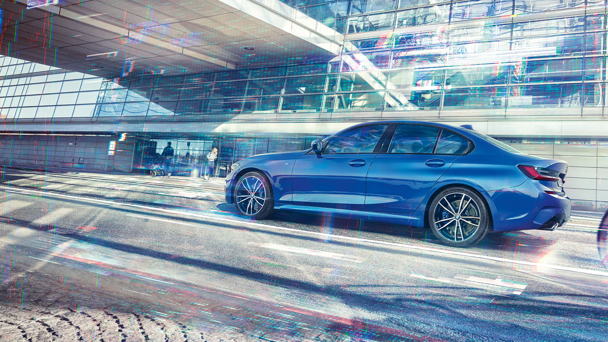 BMW Série 3 Berlina, perspetiva lateral. Perspetiva lateral diurna do BMW Série 3 Berlina parado em frente de um edifício em vidro.