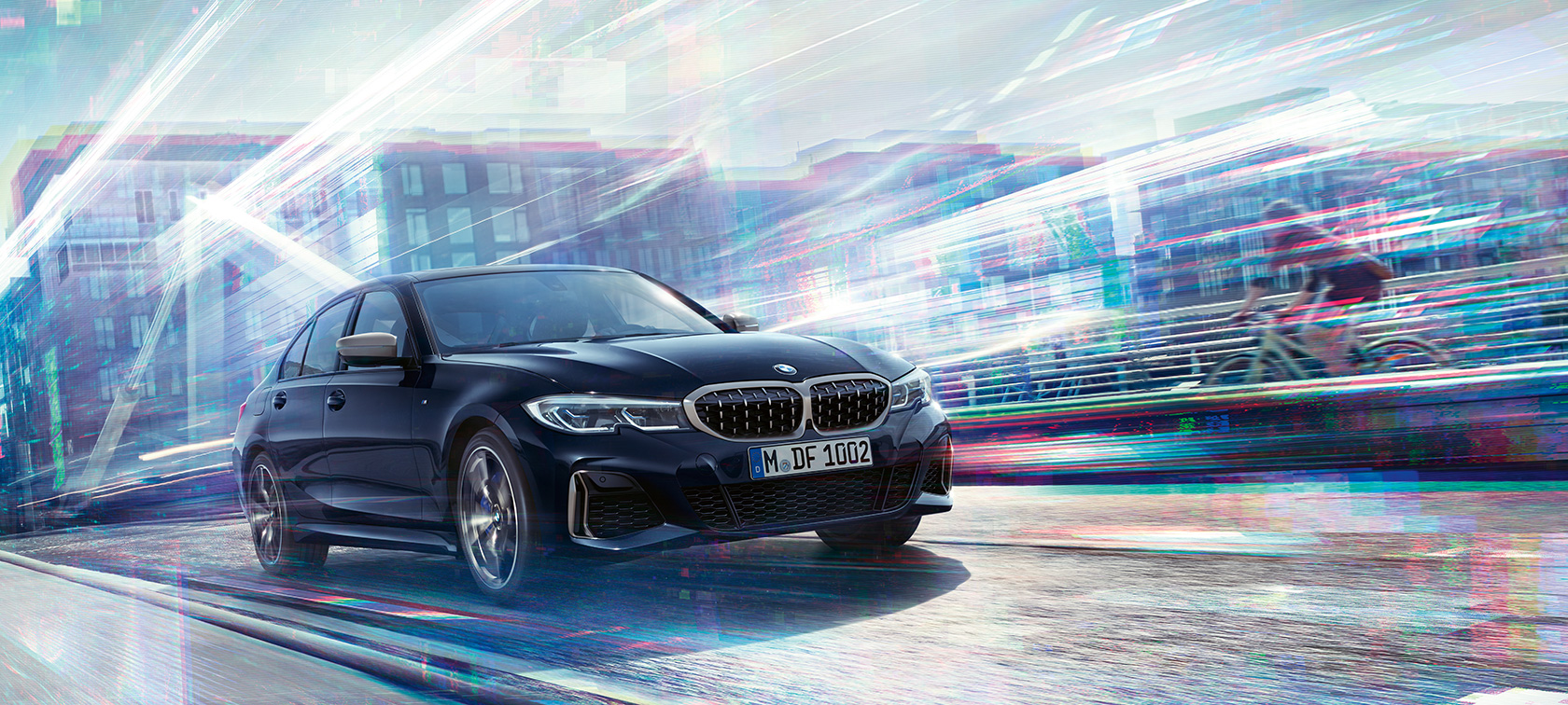 BMW Série 3 Berlina, BMW M340i xDrive. Perspetiva lateral a três quartos do BMW M340i xDrive em movimento numa estrada urbana.