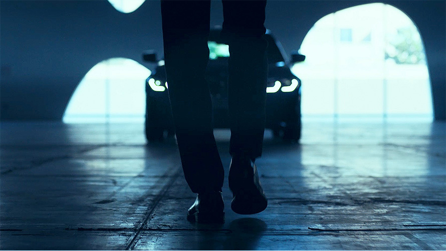 BMW Série 3 Berlina (G20), dianteira. Perspetiva traseira de um homem à frente do BMW Série 3 Berlina (G20) no asfalto.