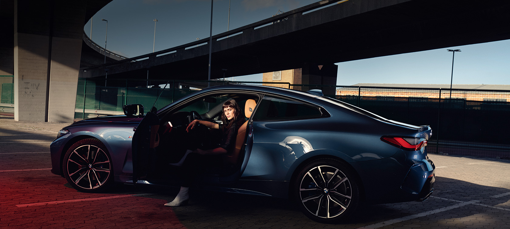 Perspetiva traseira a três quartos do BMW Série 4 Coupé, G22, 2020 BMW Série 4 Coupé, G22, 2020, pintura azul Arctic Race metalizada, perspetiva traseira a três quartos dos faróis traseiros com um modelo ao lado do automóvel