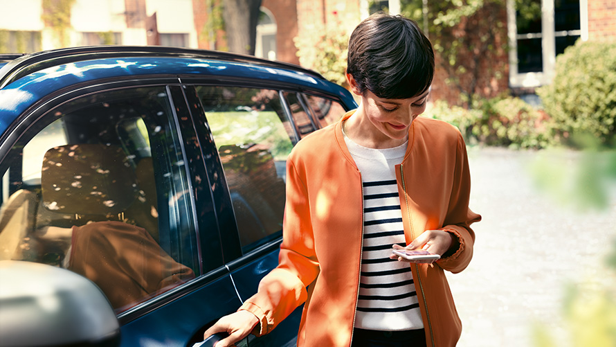 BMW Service, mulher com um smartphone ao lado da porta do seu BMW BMW Service, mulher com um smartphone ao lado da porta do seu BMW