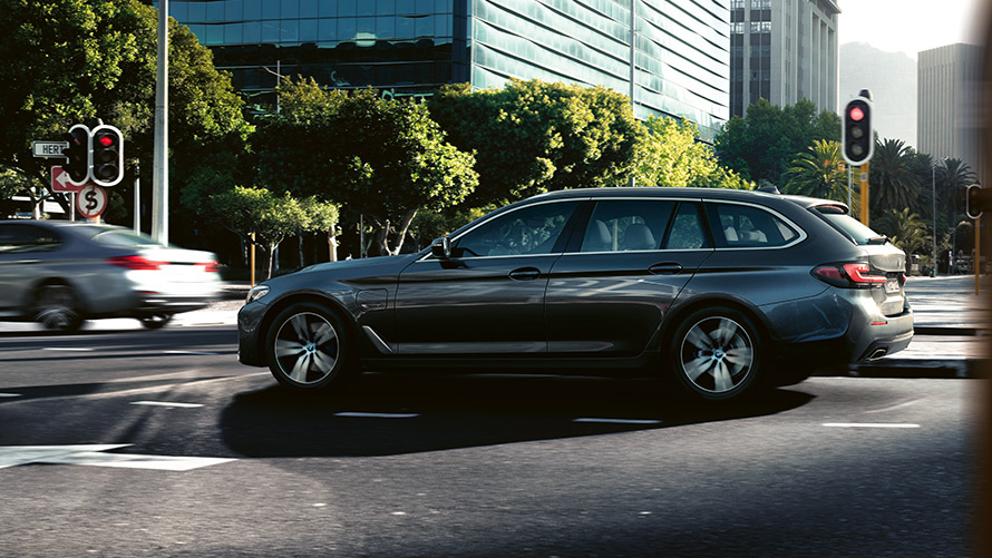 BMW 530e Touring, G31, LCI, em cinza Sophisto metalizada, em movimento no tráfego urbano BMW 530e Touring, G31, LCI, em cinza Sophisto metalizada, em movimento no tráfego urbano