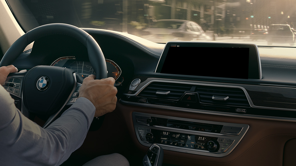 Assistente pessoal inteligente BMW Assistente pessoal inteligente BMW: homem a conduzir um BMW, grande plano do Live Cockpit Professional