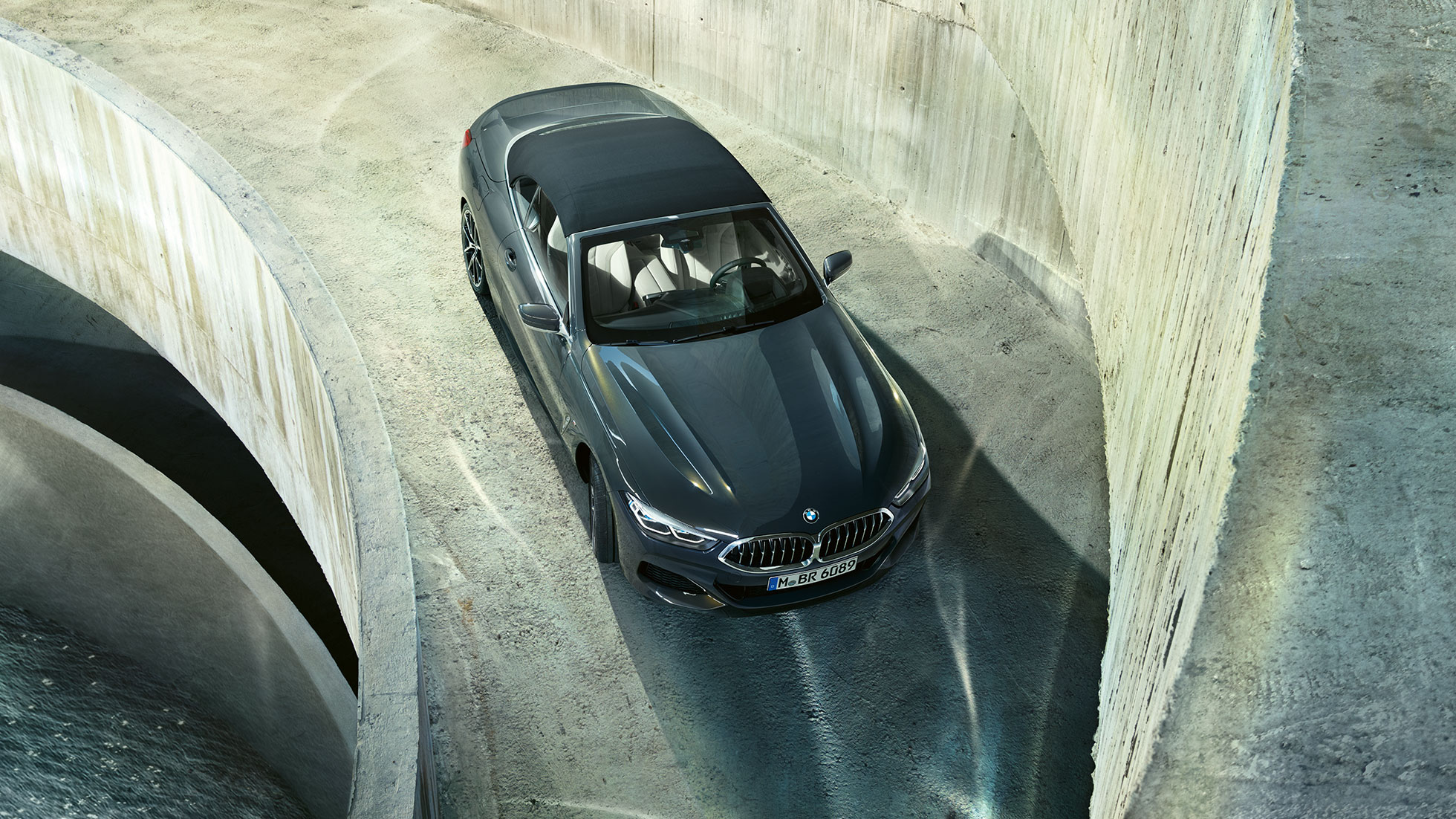 BMW M850i xDrive em cinza Dravit metalizado com capota flexível em preto, perspetiva de topo. BMW M850i xDrive em cinza Dravit metalizado com capota flexível em preto, perspetiva de topo.