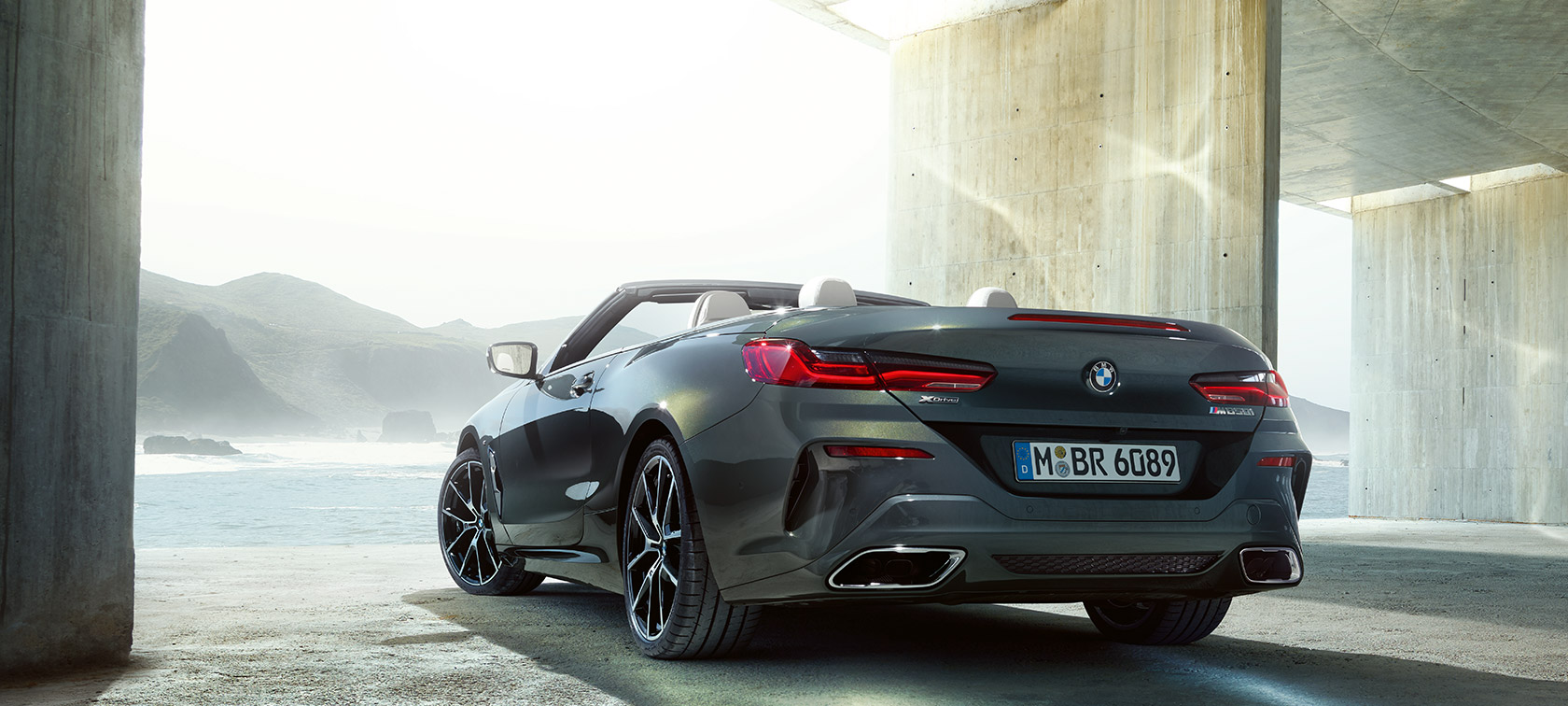 BMW M850i xDrive em cinza Dravit metalizado, perspetiva traseira esquerda a três quartos. BMW M850i xDrive em cinza Dravit metalizado, perspetiva traseira esquerda a três quartos.