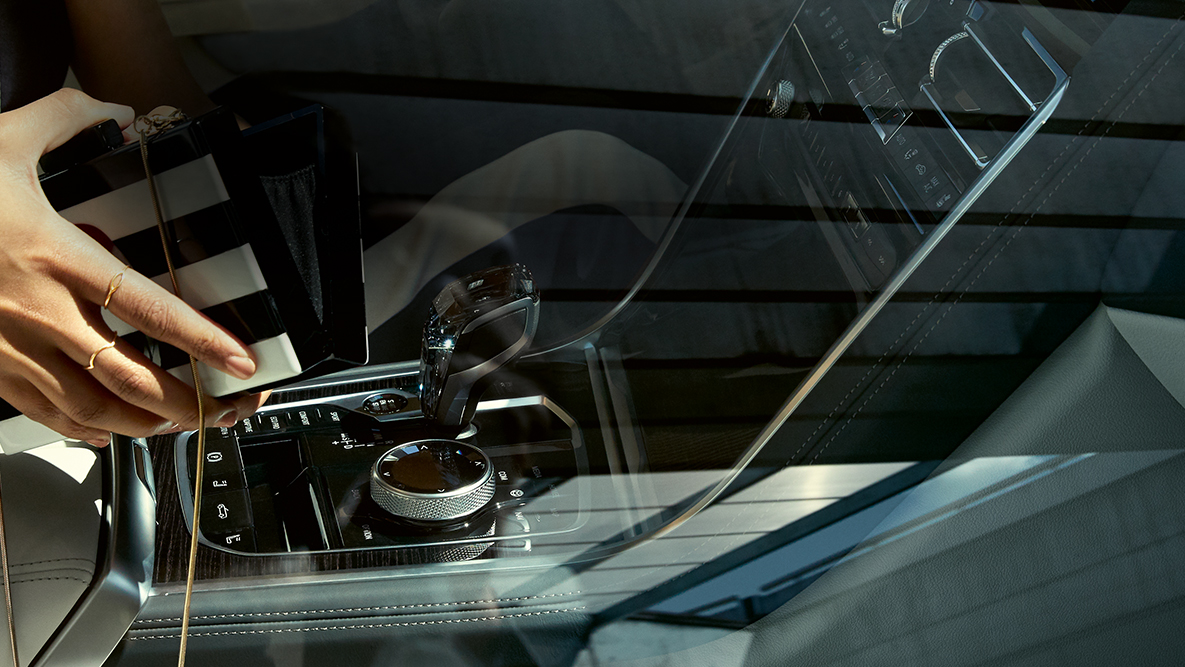 BMW M850i xDrive, interior, aplicação em vidro CraftedClarity, mulher com mala de mão aberta. BMW M850i xDrive, interior, aplicação em vidro CraftedClarity, mulher com mala de mão aberta.