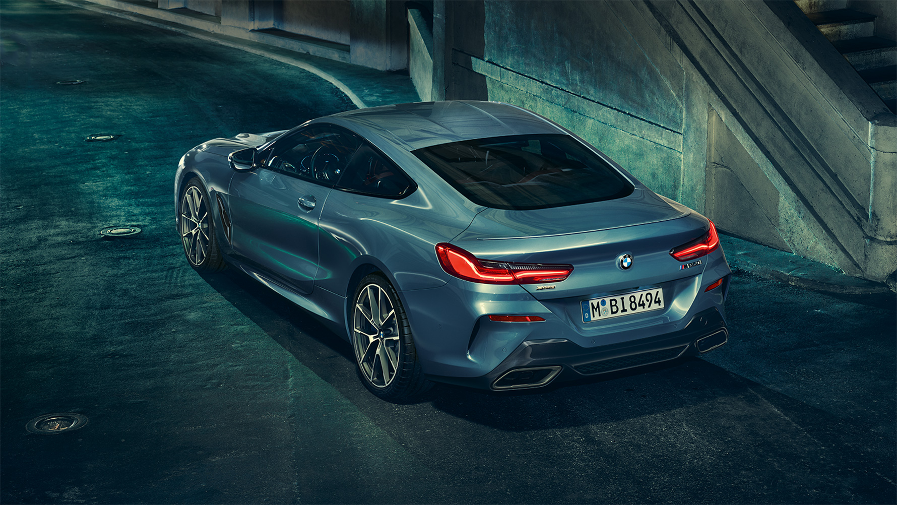 BMW 8 Series Coupé, three-quarter rear shot Three-quarter rear shot of the BMW 8 Series Coupé at night in front of an urban setting.