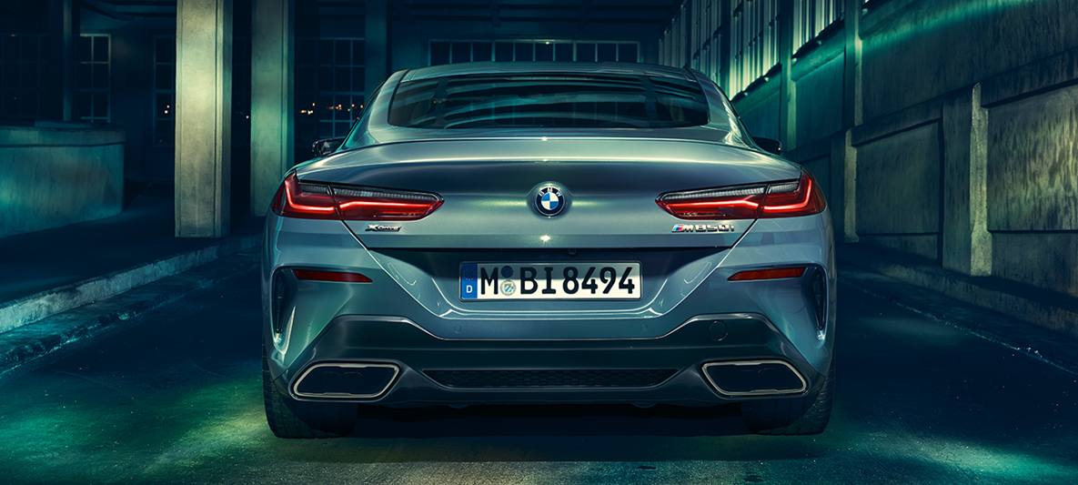 BMW Série 8 Coupé, imagem traseira Visão traseira do BMW Série 8 Coupé à noite em cebário urbano.