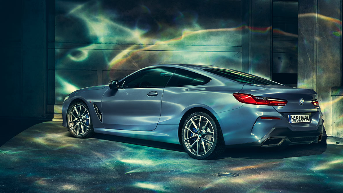 BMW Série 8 Coupé, perspetiva traseira a três quartos. Perspetiva traseira a três quartos do BMW Série 8 Coupé à noite num cenário urbano.