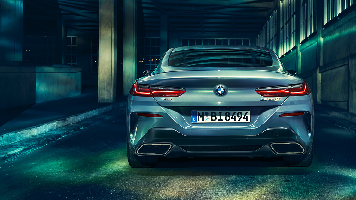 BMW Série 8 Coupé, perspetiva traseira. Perspetiva traseira do BMW Série 8 Coupé à noite num cenário urbano.
