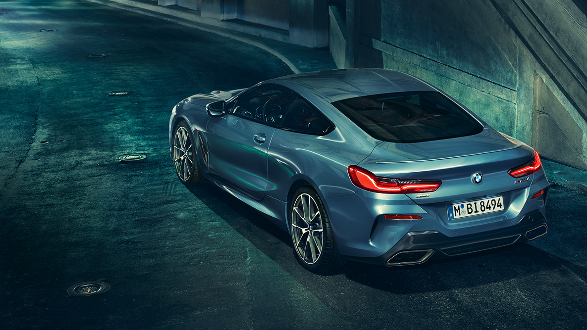 BMW Série 8 Coupé, perspetiva traseira a três quartos. Perspetiva traseira a três quartos do BMW Série 8 Coupé à noite num cenário urbano.