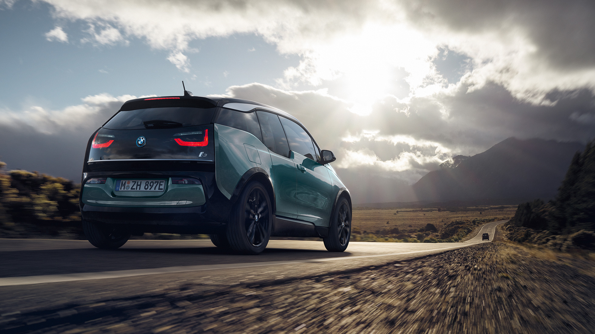BMW i3 2018 em movimento em autoestrada, perspetiva traseira a três quartos BMW i3 I01 2018 bege Jucaro com realce em cinza Frozen metalizado em movimento em autoestrada, perspetiva traseira a três quartos