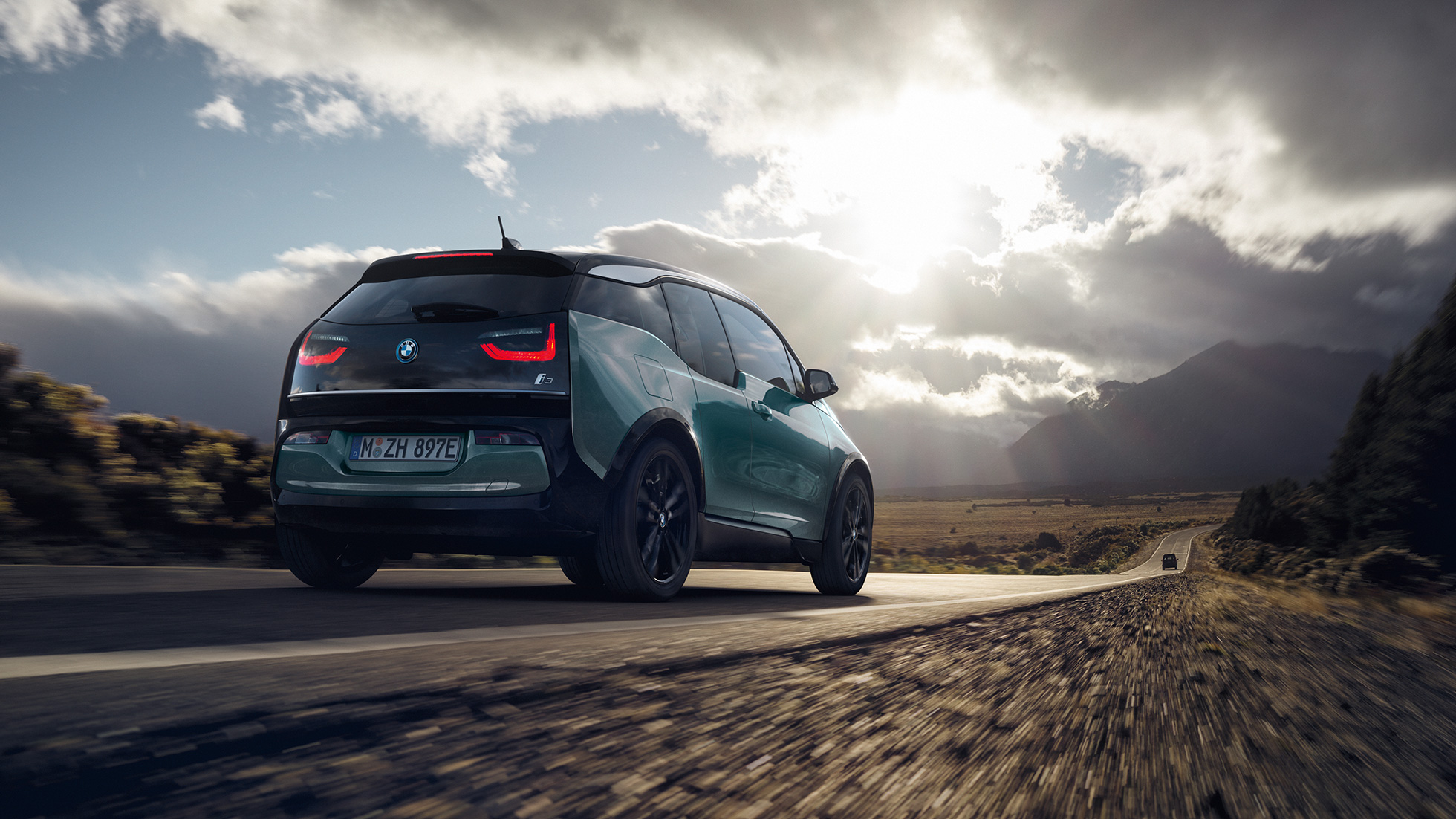 BMW i3 2018 em movimento em autoestrada, perspetiva traseira a três quartos BMW i3 I01 2018 bege Jucaro com realce em cinza Frozen metalizado em movimento em autoestrada, perspetiva traseira a três quartos