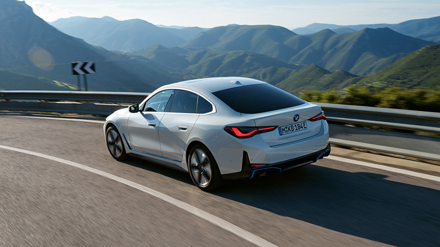 Perspetiva traseira a três quartos, BMW i4 eDrive40, G26, 2021, em movimento BMW i4 eDrive40, G26, 2021, pintura branco Mineral, perspetiva traseira a três quartos, em movimento