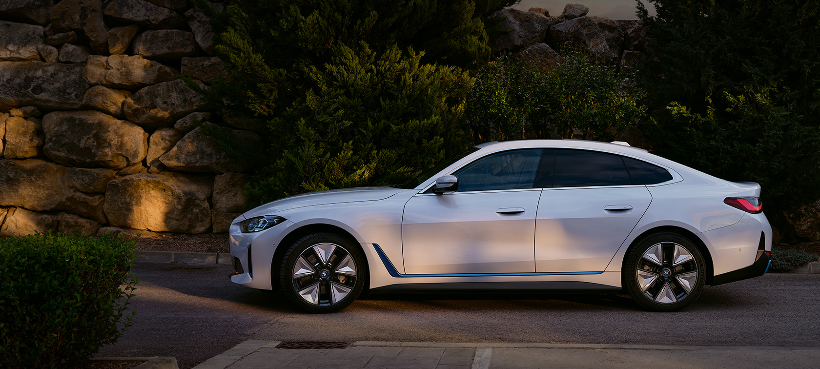 BMW eDrive40, G26, 2021, pintura branco Mineral metalizada, perspetiva frontal a três quartos, em frente a um cenário de lago com encosta