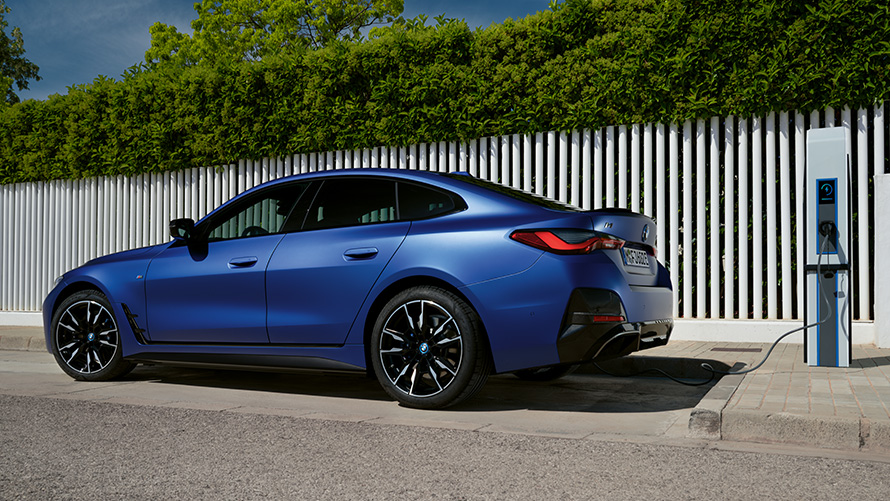 Perspetiva lateral, BMW i4 M50, G26, 2021, num posto de carregamento rápido BMW i4 M50, G26, 2021, pintura azul Frozen Portimao BMW Individual metalizada, perspetiva lateral, num posto de carregamento rápido