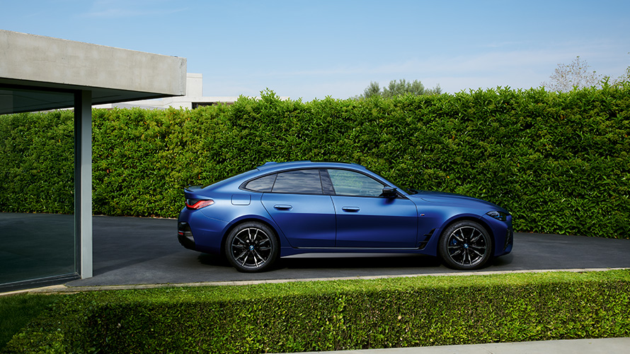 Perspetiva traseira, BMW i4 M50, G26, 2021, em movimento numa estrada secundária BMW i4 M50, G26, 2021, pintura azul Frozen Portimao BMW Individual metalizada, perspetiva traseira, em movimento numa estrada secundária
