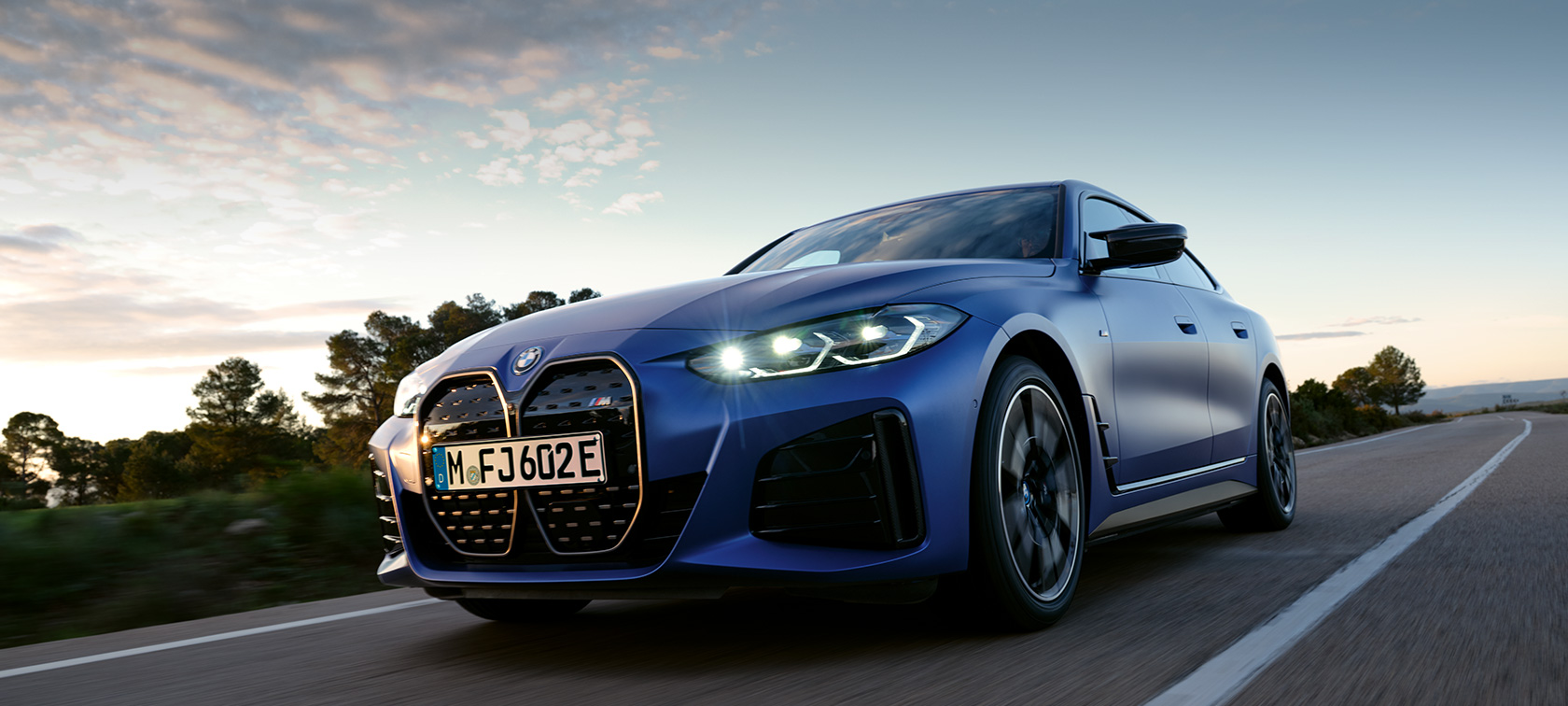 BMW i4 M50, G26, 2021, perspetiva lateral, parado em frente a um piso com pedras BMW i4 M50, G26, 2021, pintura azul Frozen Portimao BMW Individual metalizada, perspetiva lateral, parado em frente a um piso com pedras