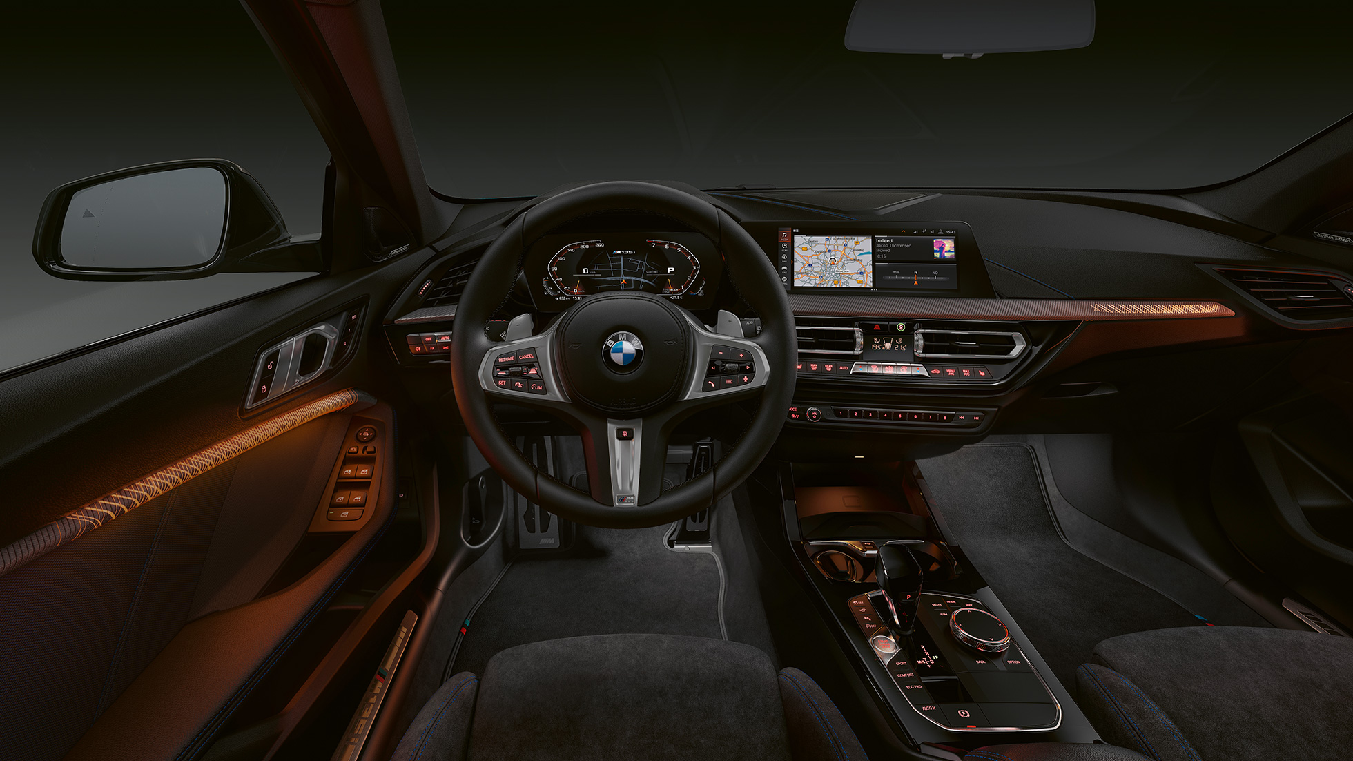 BMW M135i xDrive, posto de condução. Interior de topo do BMW M135i xDrive com frisos interiores retroiluminados.