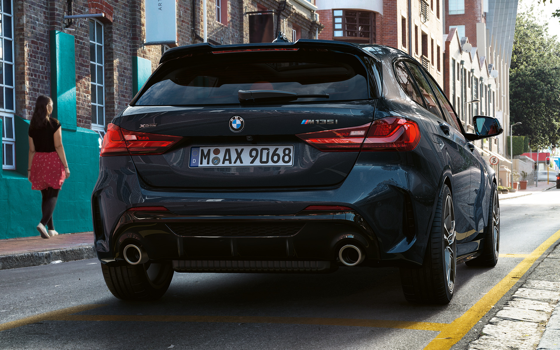 BMW M135i xDrive (F40) em preto Sapphire metalizada, perspetiva traseira, a estacionar